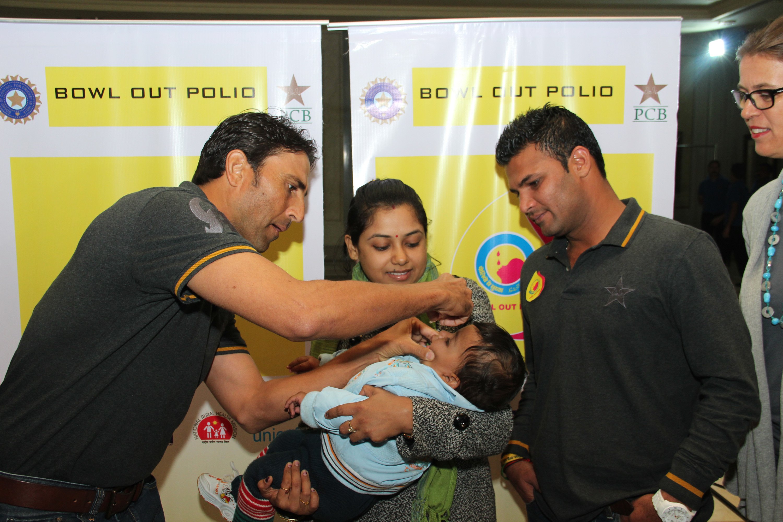 pakistani batsman younus khan administers polio drops to children at an event in new delhi as fellow batsman imran farhat looks on