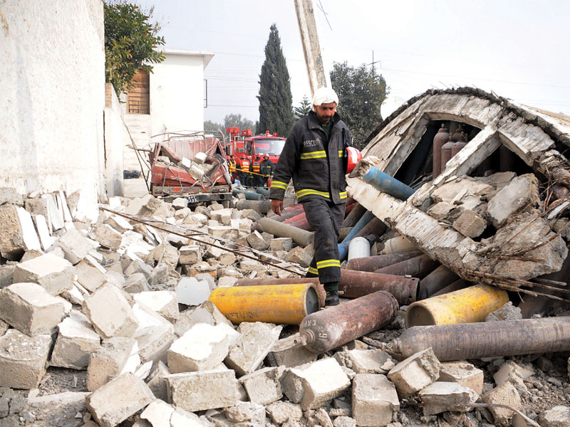 a rescue worker sifts through the debris of the building photo waseem imran express