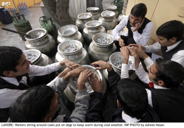 a group of servers sit around coals to keep themselves warm as the mercury plummeted in lahore photo inp a group of servers sit around coals to keep themselves warm as the mercury plummeted in lahore photo inp