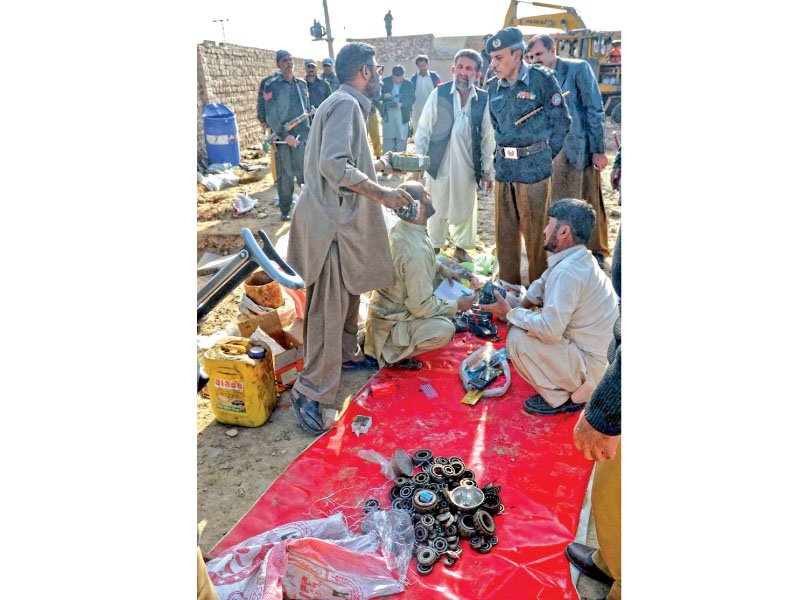 police and officials of bomb disposal squad categorising the seized arms ammunition and explosives recovered from a vacant plot in quetta photo ppi