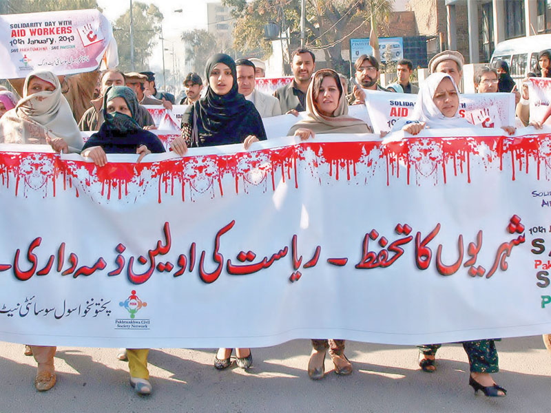 protesters outside the peshawar press club demonstrate against the killing of aid workers photo inp