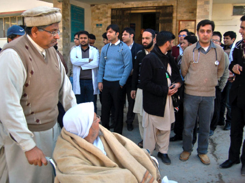 a patient on wheel chair looks at the protesting doctors outside the benazir shaheed hospital on thursday photo muhammad javaid express