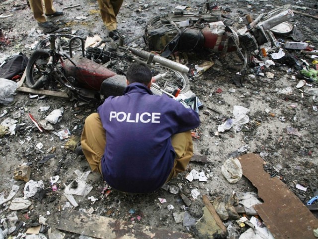 Pakistani security officials examine the site of a bomb attack in Quetta on January 10, 2013. PHOTO: AGENCIES