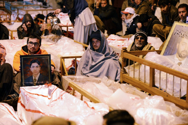 shia muslims demonstrate and sit amongst the coffins and portraits of bomb blast victims in quetta on january 12 2013 photo afp shia muslims demonstrate and sit amongst the coffins and portraits of bomb blast victims in quetta on january 12 2013 photo afp