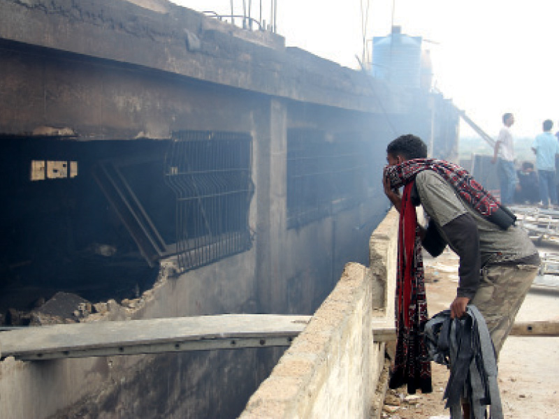 this photo taken on september 11 shows a man looking into the stitching room on the third floor of the factory photo ayesha mir file