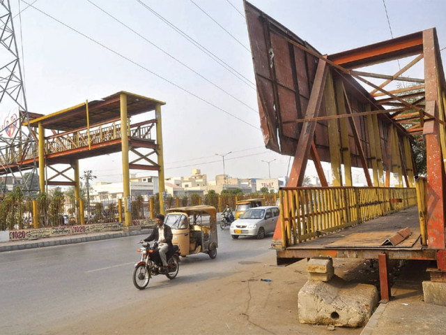 pedestrians wishing to cross the 40 metre wide sharae usman one of the busiest roads in the city have to risk their lives because a portion of the pedestrian bridge has yet to be put up after it was damaged back in december last year photo express pedestrians wishing to cross the 40 metre wide sharae usman one of the busiest roads in the city have to risk their lives because a portion of the pedestrian bridge has yet to be put up after it was damaged back in december last year photo express