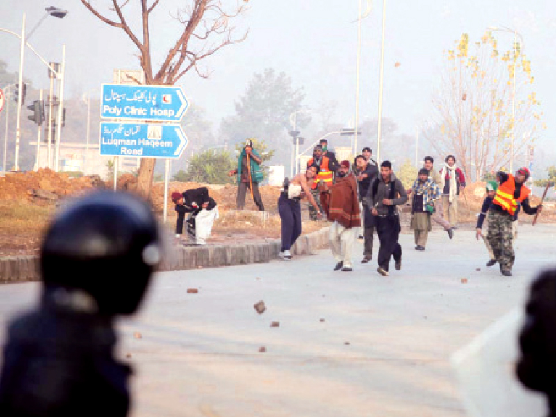 an mqi activist shows the shell of a bullet allegedly fired by the police top left activists throw stones at policemen at jinnah avenue photo nni