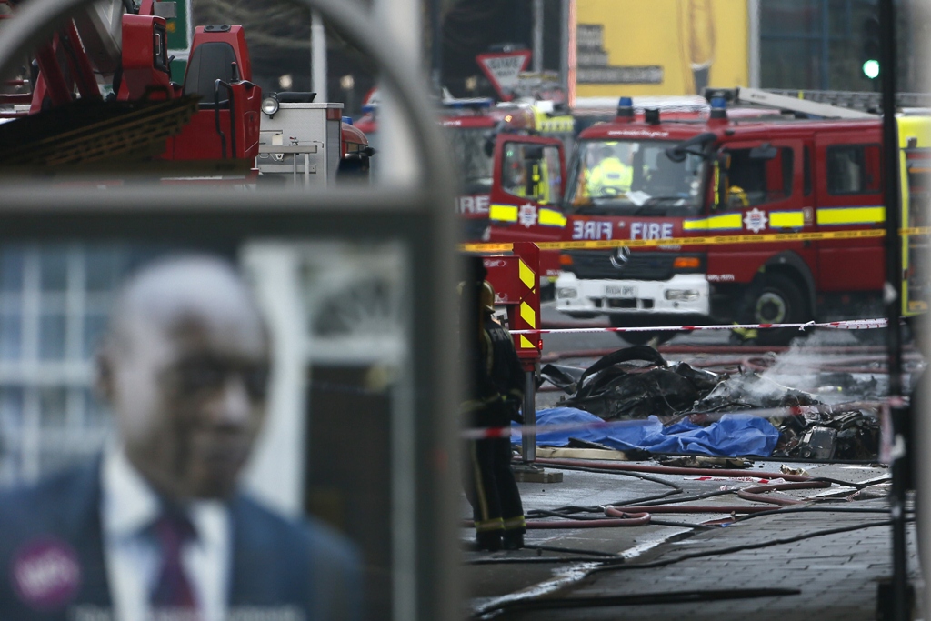 smoke rises from debris as police and emergency services attend the scene of a helicopter crash in vauxhall south london january 16 2013 photo reuters