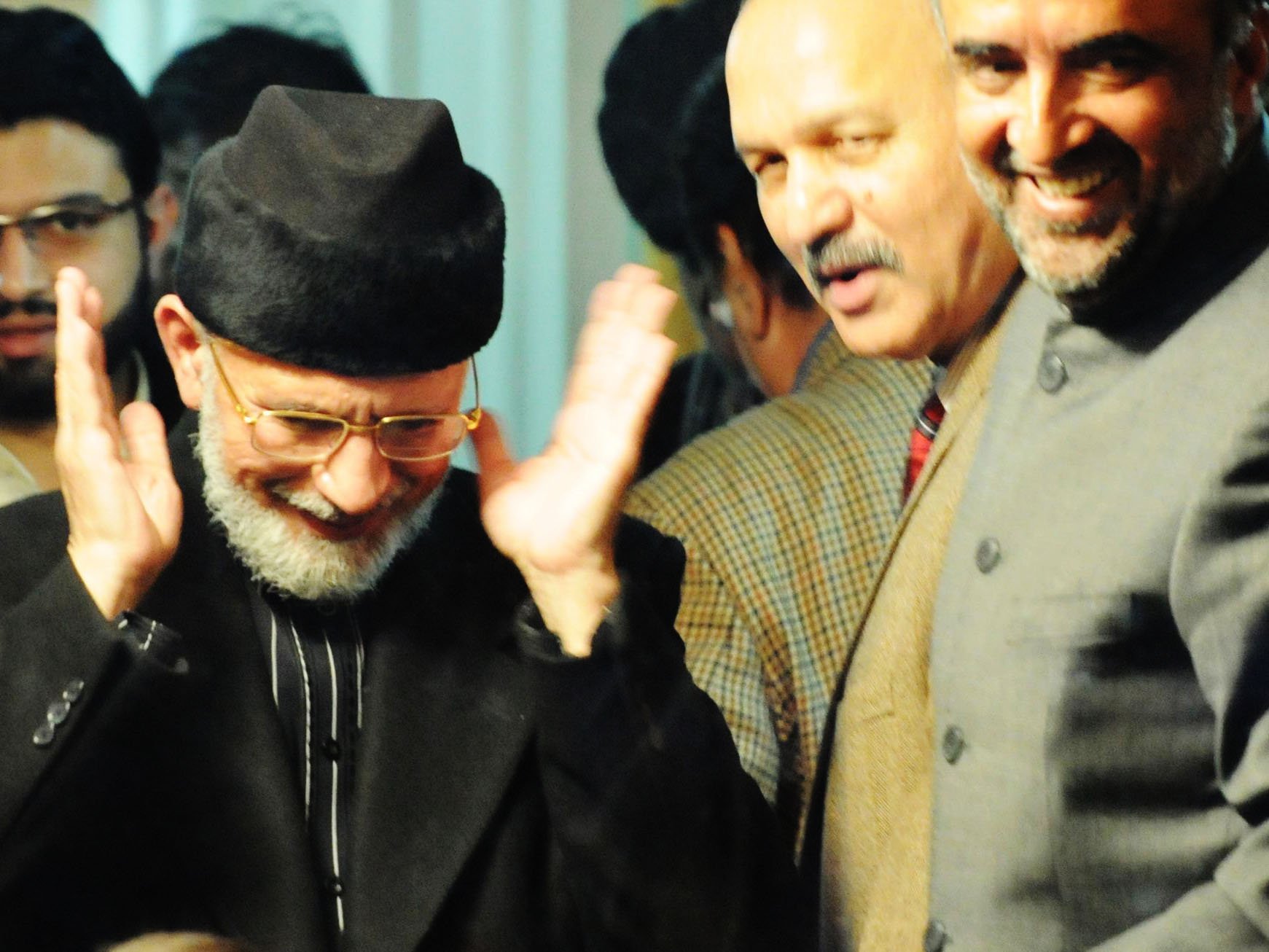 tahirul qadri prepares for evening prayers in break in negotiations as minister for information qamar zaman kaira and senator mushahid hussain syed look on photo afp