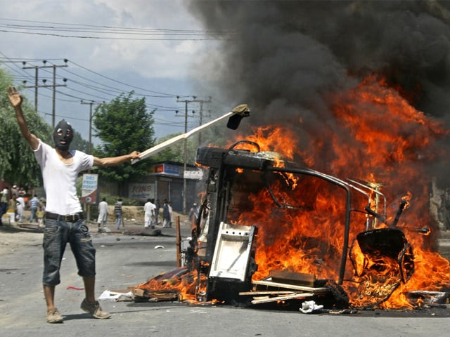 a masked kashmiri shouts anti indian slogans beside a burning police vehicle in pampore on sunday photo afp