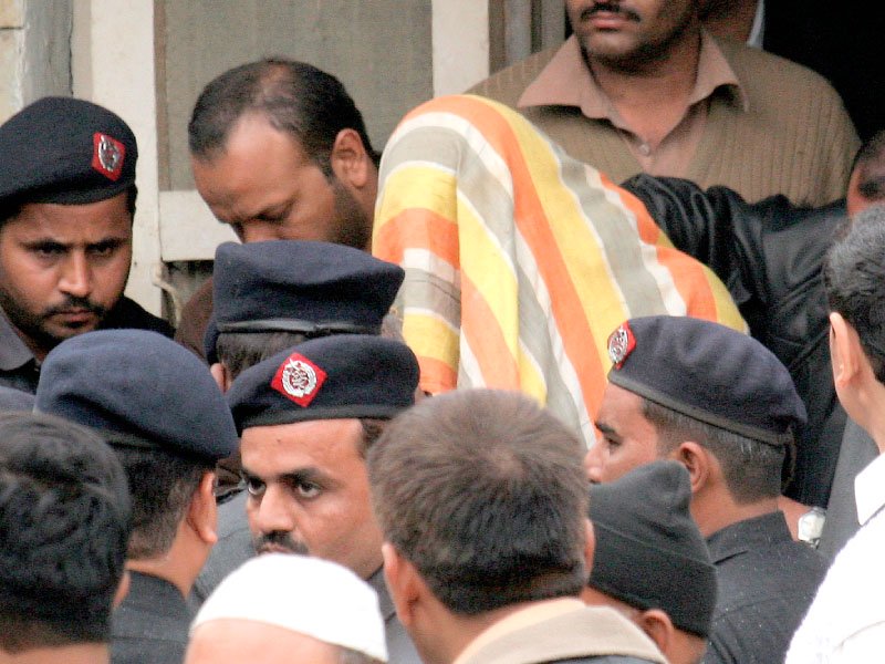 police escort prime suspect shahrukh jatoi and other suspects with covered faces after they were brought before a judge at an anti terrorism court in karachi photo athar khan