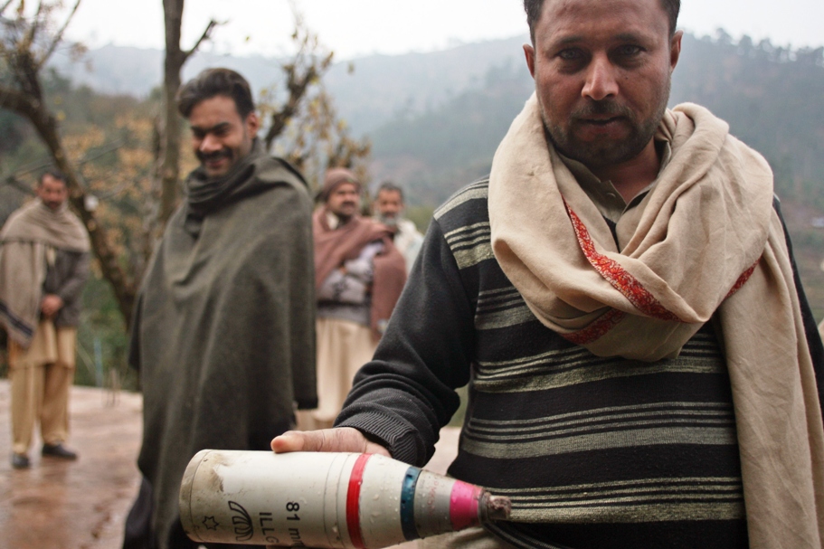 a villager in kashmir poses with a mortar shell casing claimed to have hit a home at the village of parla mohrra photo afp