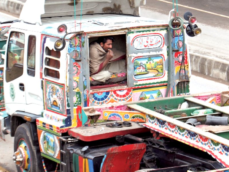 a driver rests in his truck parked on jinnah avenue on friday photo muhammad javaid