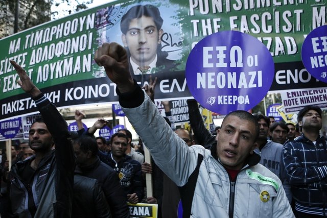 immigrants raise their arms in front of a banner depicting a late pakistani immigrant during an anti racism rally in athens january 19 2013 photo reuters