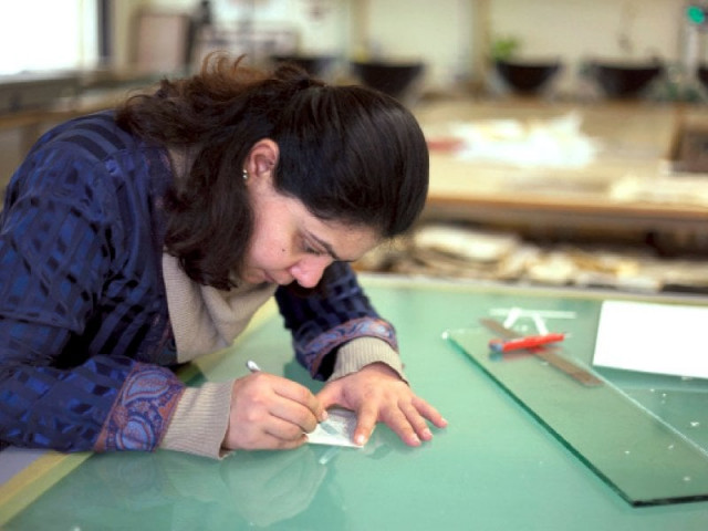 a woman working on a piece of paper right photo muhammad javaid express a woman working on a piece of paper right photo muhammad javaid express