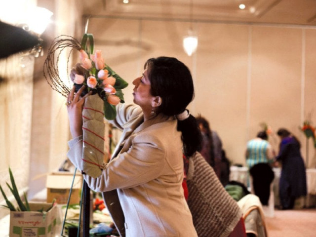 a participant putting together her flower arrangement during the event left and a finished piece up for critique photo myra iqbal express a participant putting together her flower arrangement during the event left and a finished piece up for critique photo myra iqbal express