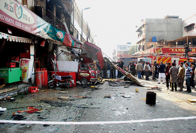 rescuers reporters and bystanders gather at the scene of a gas cylinder explosion at the h block market in dha photo shafiq malik express rescuers reporters and bystanders gather at the scene of a gas cylinder explosion at the h block market in dha photo shafiq malik express