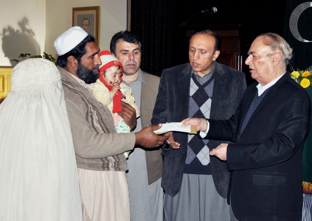 the khyber pakhtunkhwa governor giving away cheque of the compansation amount to the heirs of levies personnels photo express