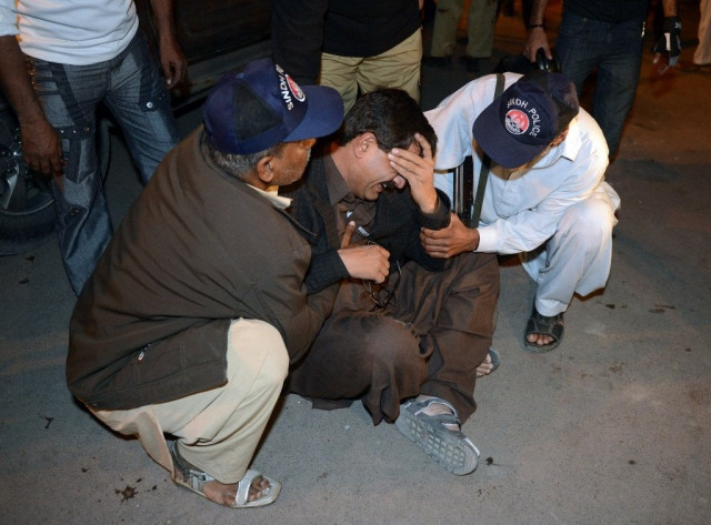 a policeman mourns the death of a colleague after the bomb blast in karachi on january 24 2013 photo afp a policeman mourns the death of a colleague after the bomb blast in karachi on january 24 2013 photo afp