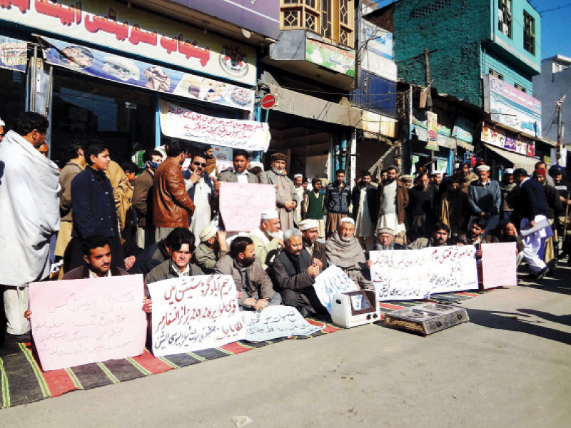 residents hold placards to draw attention of concerned authorities during their protest against power cuts in swat on thursday photo online