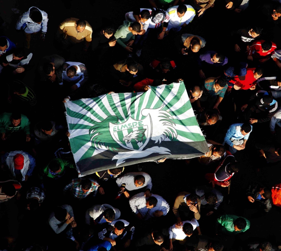 protesters and fans of al masry football club wave their club colours as they take part in a demonstration in front of the prison in port said photo afp