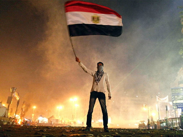 a protester waves the egyptian flag in the midst of tear gas fired by riot police in tahrir square photo afp a protester waves the egyptian flag in the midst of tear gas fired by riot police in tahrir square photo afp