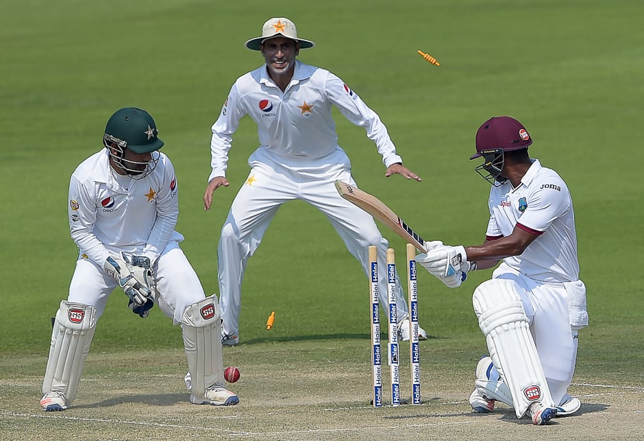 West Indies' batsman Leon Johnson (R) is bowled out by Pakistani spinner Yasir Shah (unseen) as wicketkeeper Sarfraz Ahmed (L) and teammate Younis Khan look on during the fourth day of the second Test between Pakistan and the West Indies at the Sheikh Zayed Cricket Stadium in Abu Dhabi. PHOTO: AFP