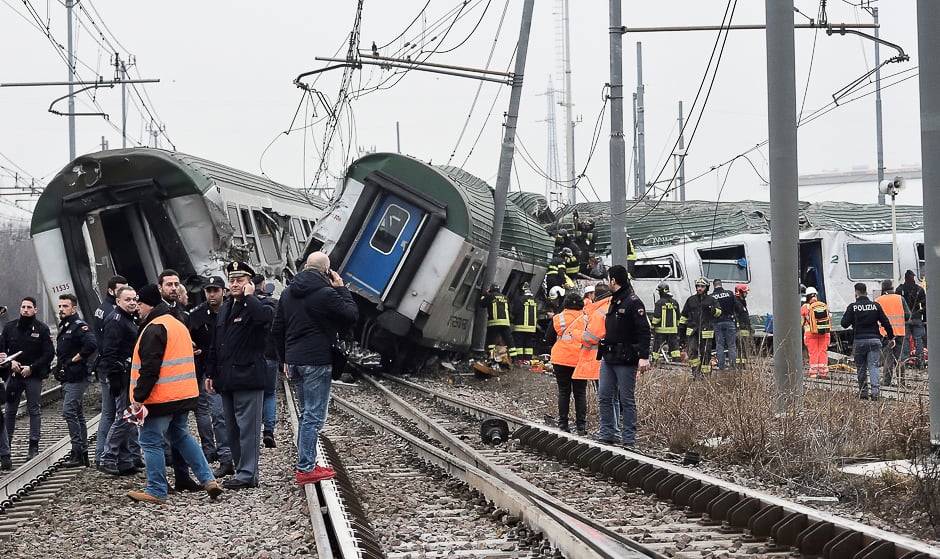 Rescue workers and police officers stand near derailed trains in Pioltello, on the outskirts of Milan, Italy. PHOTO: REUTERS