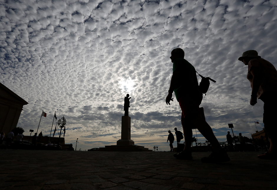 Tourists walk near a statue of former Prime Minister Gorg Borg Olivier (C) who won Malta its independence in 1964, at Castille Place in Valletta, Malta. PHOTO: REUTERS