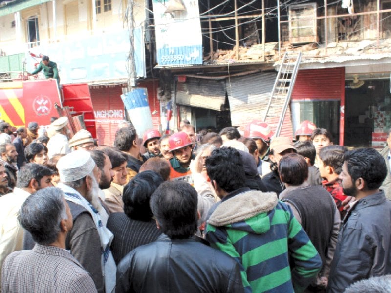 people gather at the site of the fire in raja bazaar photo agha mehroz express