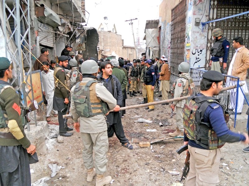 paramilitary soldiers and policemen gather at the site of the blast photo afp