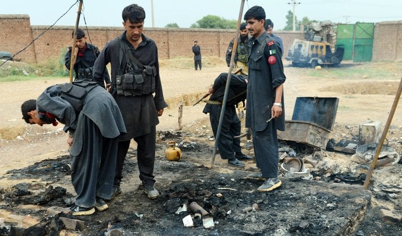 a file photo of security personnel inspecting a burnt out police checkpost following an attack by armed militants last year photo afp