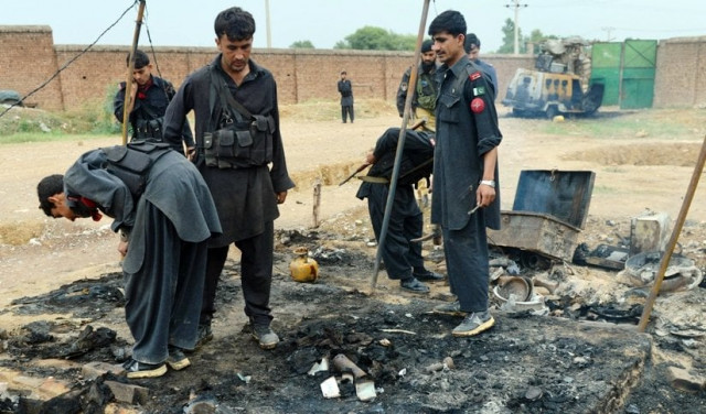 a file photo of security personnel inspecting a burnt out police checkpost following an attack by armed militants last year photo afp a file photo of security personnel inspecting a burnt out police checkpost following an attack by armed militants last year photo afp