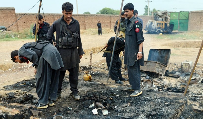a file photo of security personnel inspecting a burnt out police checkpost following an attack by armed militants last year photo afp