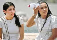 a woman places a bottle filled with ice on her head to cool down at st peter s square in the vatican during a heatwave photo afp