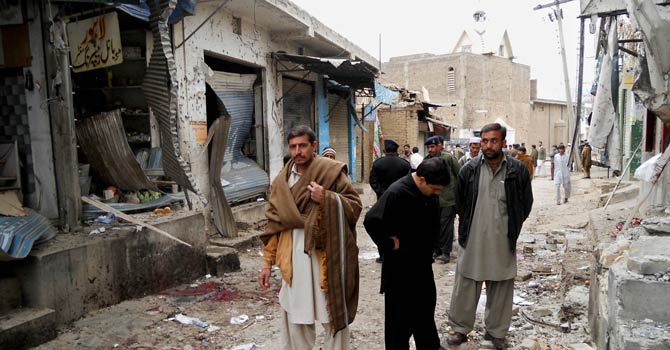 onlookers stand over the site of a bomb blast outside a mosque in hangu on february 1 2013 photo afp