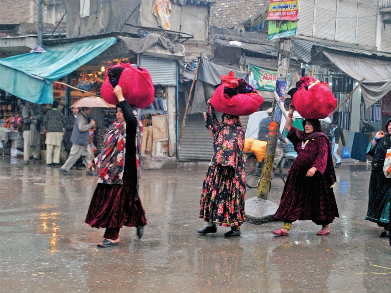 women cross the road in qissa khawani bazaar as rain lashes the provincial capital on sunday photo muhammad iqbal express