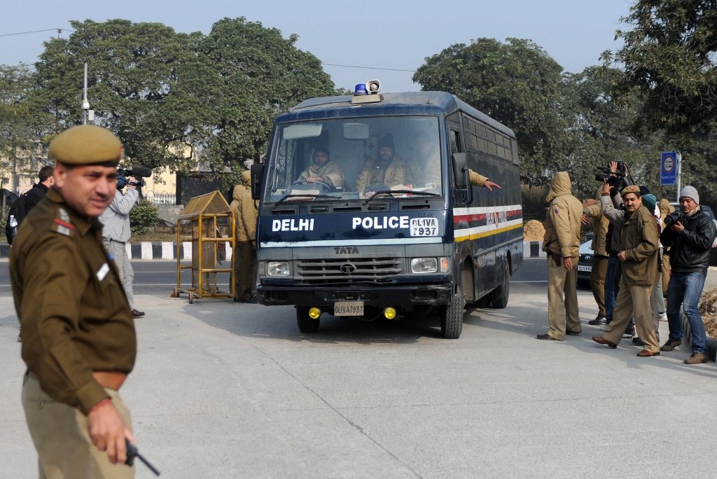 indian police personnel guide a vehicle which is believed to be carrying the accused in a gangrape and murder case at an entrance to saket district court in new delhi on january 7 2013 photo afp