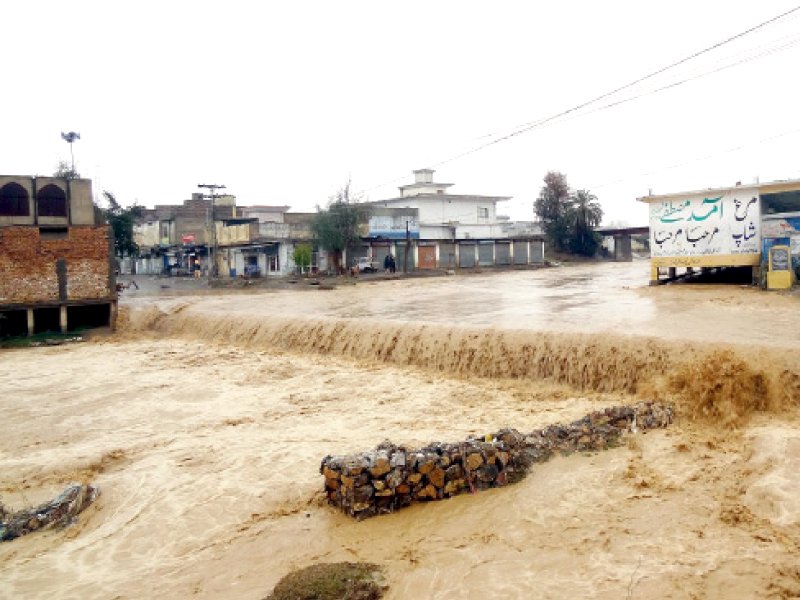 a drain overflows after heavy rains caused flooding in haripur photo inp