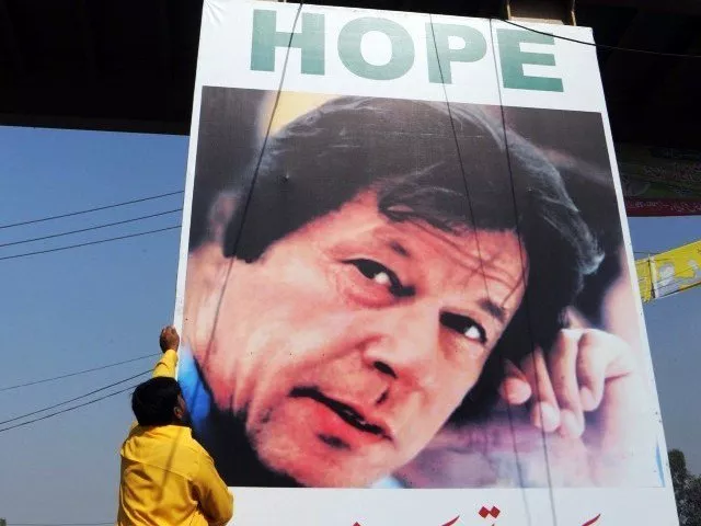 a worker installs a banner showing a portrait of pakistani politician imran khan on a busy street in lahore on october 27 2011 photo afp a worker installs a banner showing a portrait of pakistani politician imran khan on a busy street in lahore on october 27 2011 photo afp