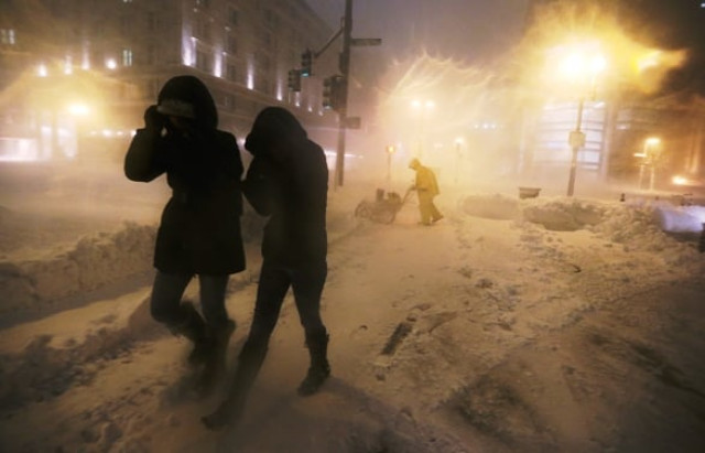 boston ma people walk through a driving snow as a worker clears a sidewalk in the back bay neighborhood on february 8 2013 photo afp boston ma people walk through a driving snow as a worker clears a sidewalk in the back bay neighborhood on february 8 2013 photo afp
