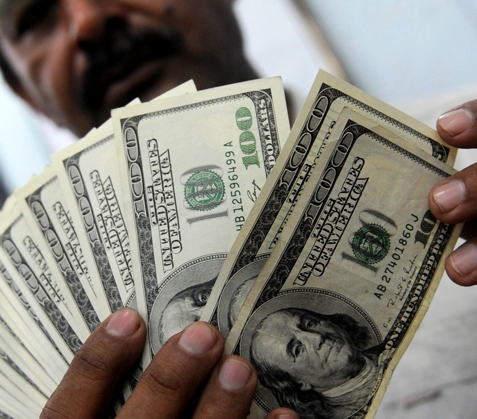 a money dealer counts us dollar notes at a money market in karachi photo afp