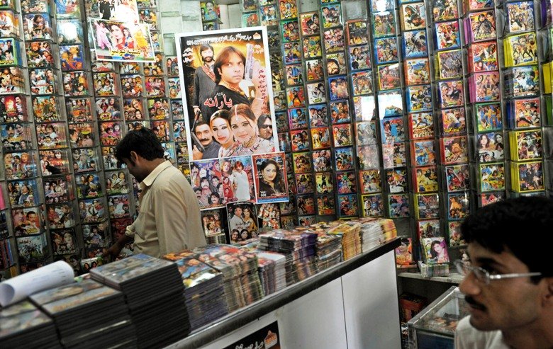 a file photo of a shopkeeper as he browses through music cds in his shop in peshawar photo afp