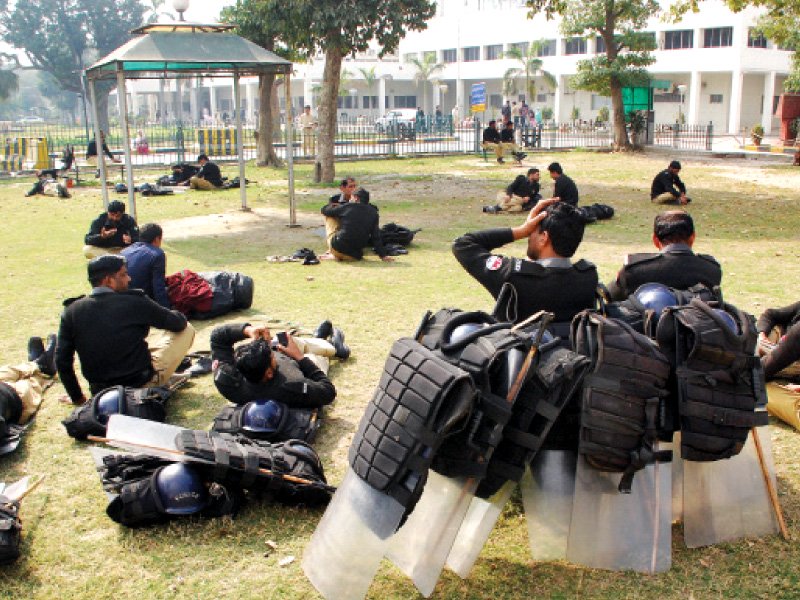 riot police rest on a green patch near the yda hunger strike camp photo riaz ahmed express