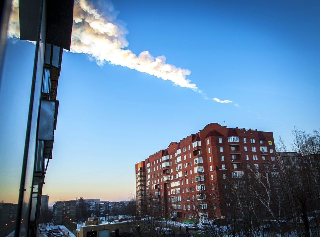 the trail of a falling object is seen above a residential apartment block in the urals city of chelyabinsk on february 15 2013 photo afp file