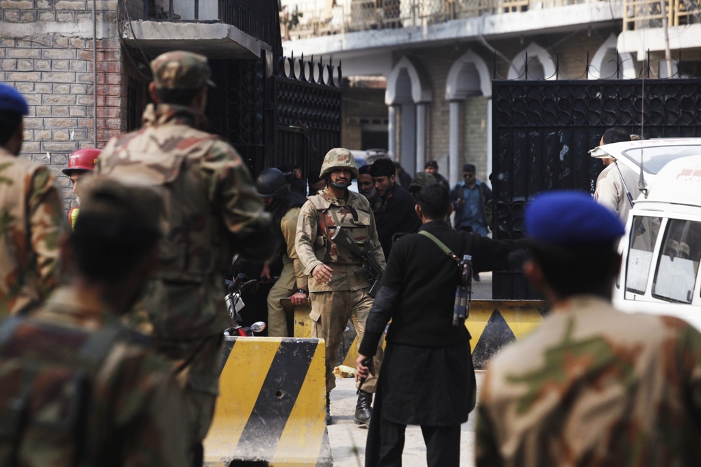 security forces gather at the entrance of the compound of a senior government official which had been raided by gunmen in peshawar february 18 2013 photo reuters