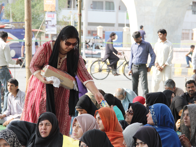 a woman distributes boxes of juice to the protesters who had turned up at teen talwar on tuesday she is just one of the volunteers who skipped work to make sure the protesters were well fed photo express