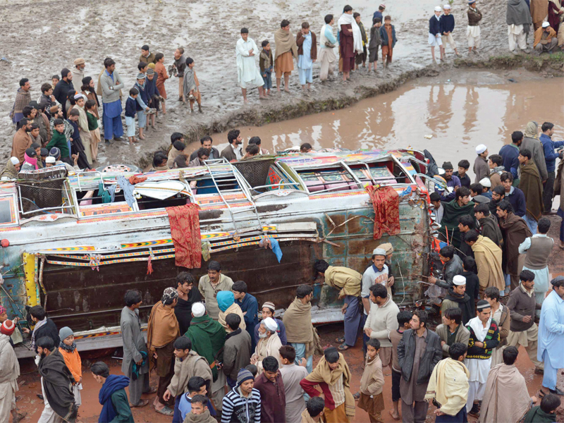 a crowd surrounds the passenger bus that fell into a canal in badhu samarbagh village on friday afternoon photo sameer raziq express