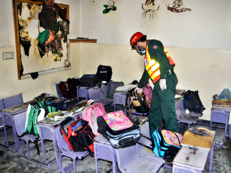 a rescue 1122 fire fighter inspects damage to the classroom photo shafiq malik express