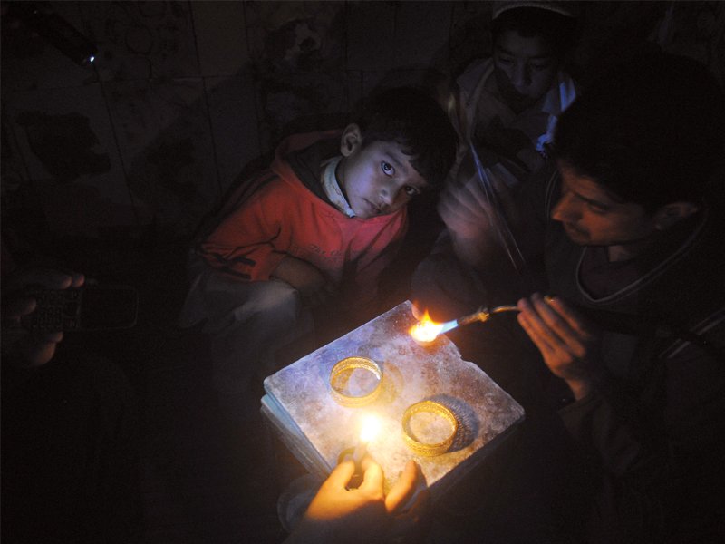 a jeweller lights candles with his blowtorch power outages have spanned a record 16 to 18 hours in the rural areas photo muhammad iqbal express